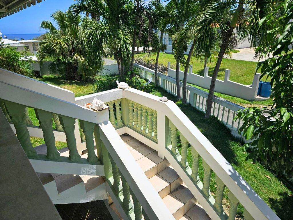An outdoor staircase with a white balustrade overlooks a grassy yard with palm trees — Car 2 R 485 K2 H2 Bo Memb SECTOR BAJURA CAMUY, CAMUY, PR