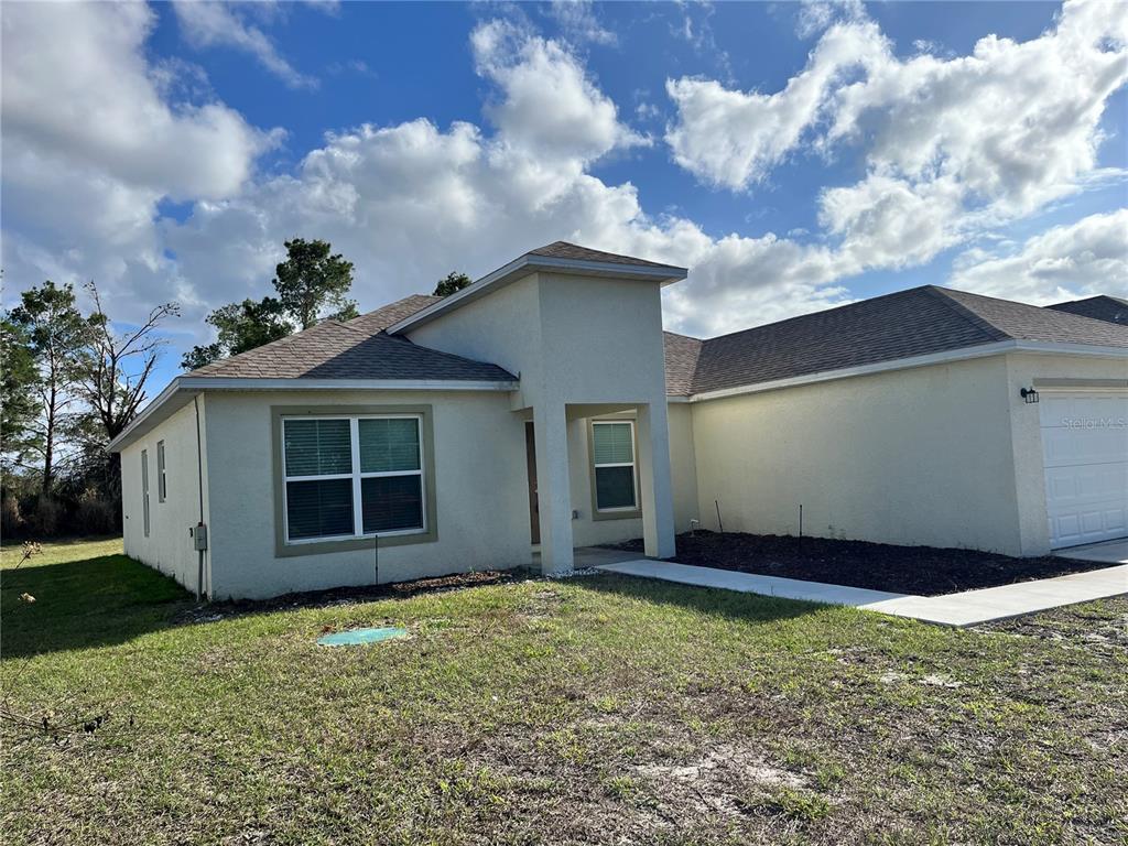 A single-story house with a beige stucco exterior, a gray shingled roof, and a garage — 4441 PALMARITO STREET, SEBRING, FL