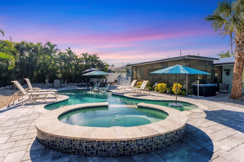 A backyard swimming pool and hot tub with lounge chairs and umbrellas on a patio — 154 CRESCENT DRIVE, ANNA MARIA, FL