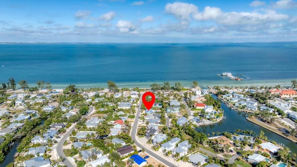 An aerial view shows a coastal neighborhood with a red location pin on a house — 154 CRESCENT DRIVE, ANNA MARIA, FL