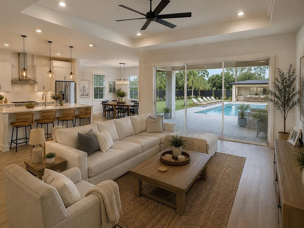 A bright open-concept living room and kitchen overlook a backyard patio with a swimming pool — DE LEON DRIVE, NORTH PORT, FL