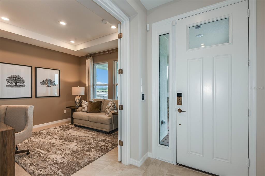 A view from a tiled entryway into a home office featuring a sofa and rug — 712 SKY SHADE DRIVE, APOLLO BEACH, FL
