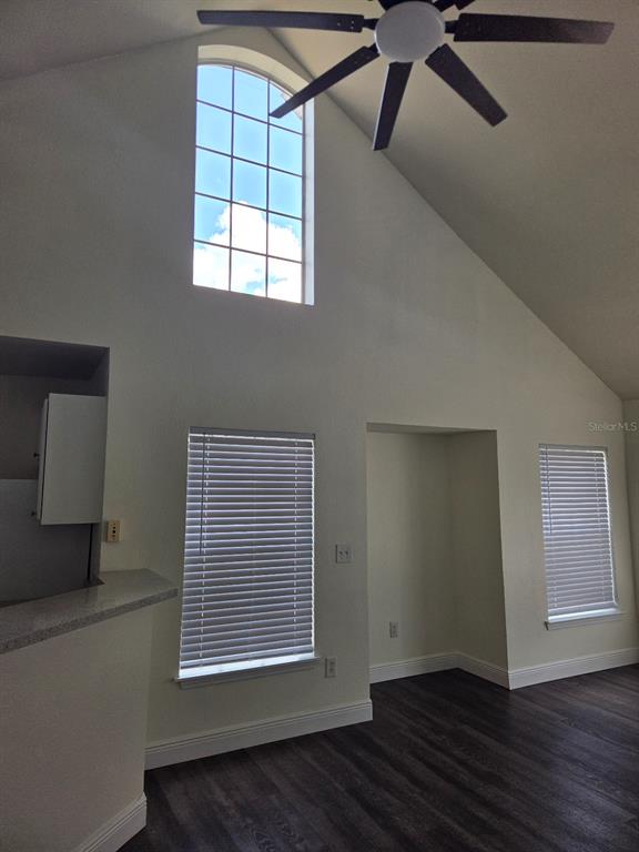 A room with a vaulted ceiling, a ceiling fan, and windows with white blinds — 9141 LEE VISTA BOULEVARD UNIT 308, ORLANDO, FL