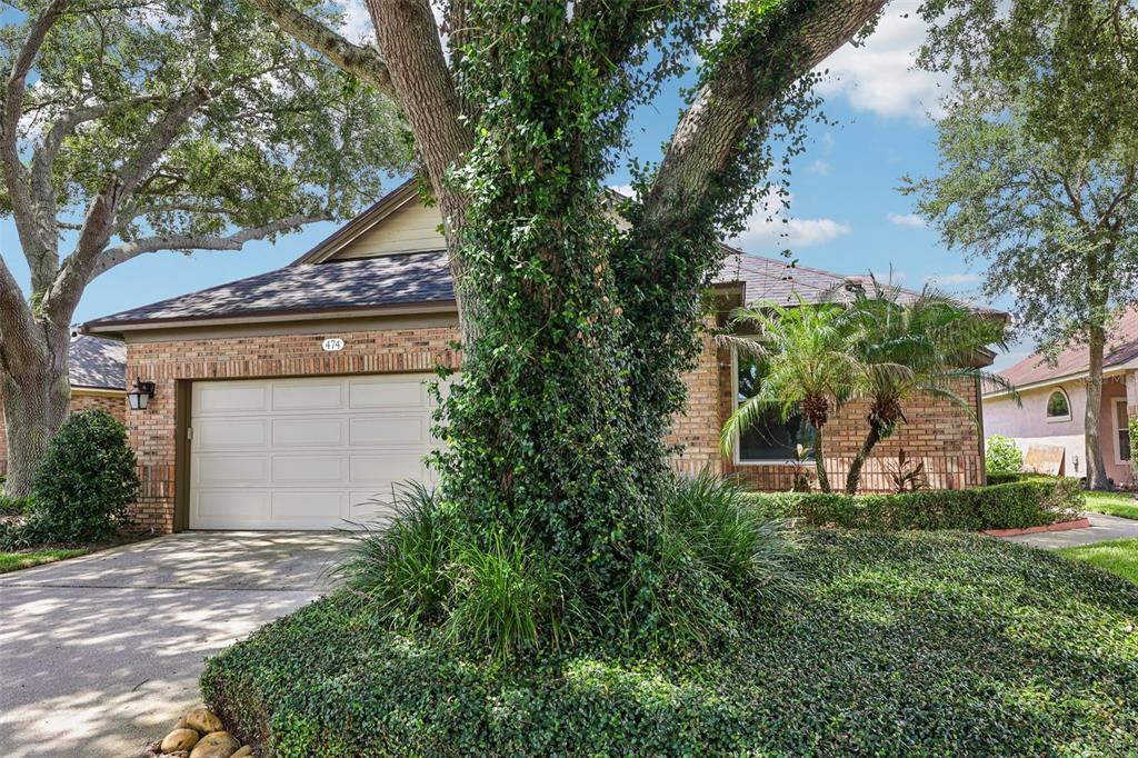 A brick house with a two-car garage and a large tree in the front yard — 474 ARROWMOUNT PLACE, LAKE MARY, FL