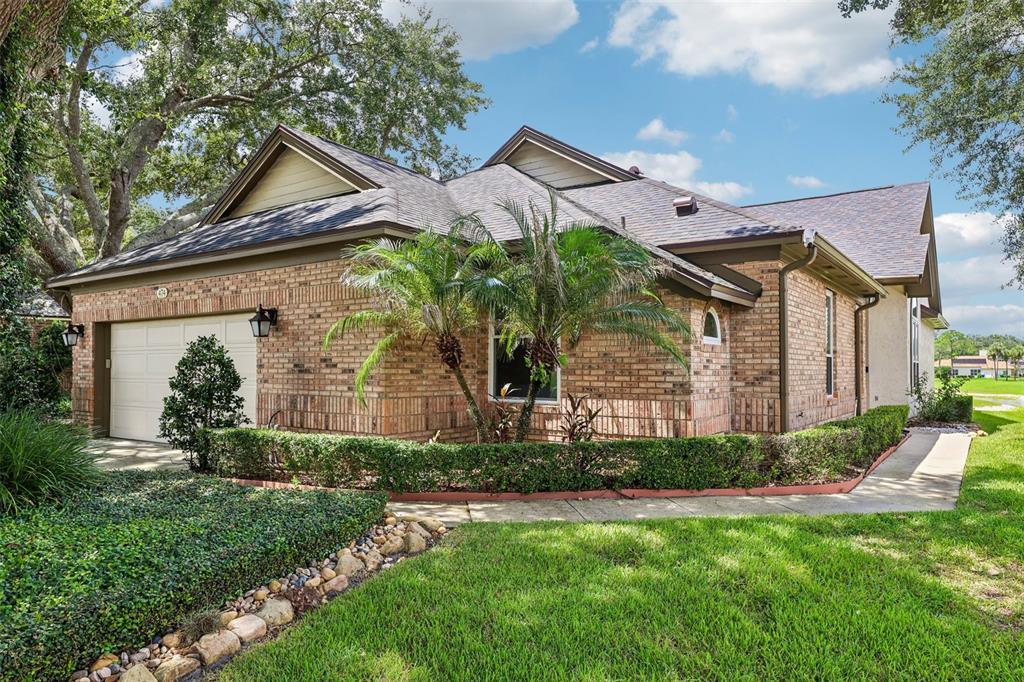A brick house with a two-car garage, a palm tree, and a manicured hedge — 474 ARROWMOUNT PLACE, LAKE MARY, FL