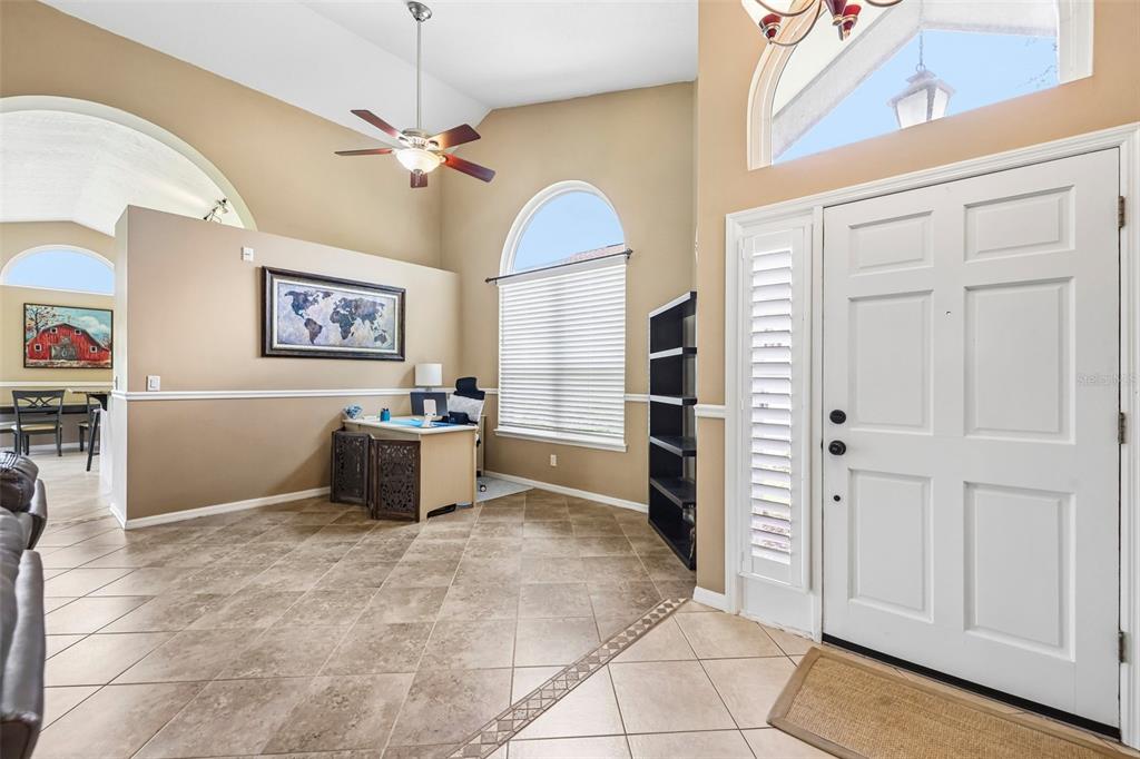 An entryway with tile flooring, a desk, a tall bookshelf, and a white front door — 474 ARROWMOUNT PLACE, LAKE MARY, FL