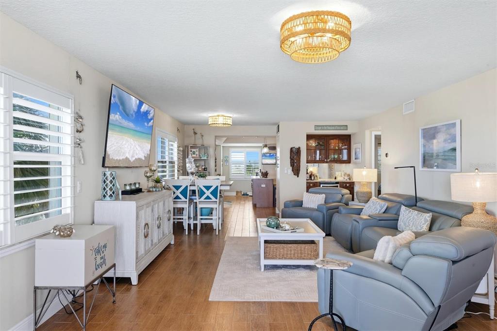 A living room features a large television, dark leather sofas, a coffee table, and a bar — 4325 GULF OF MEXICO DRIVE UNIT 408, LONGBOAT KEY, FL