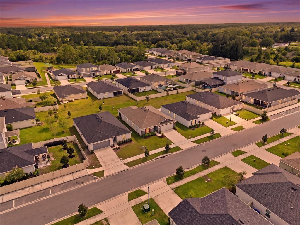 An aerial view shows a suburban neighborhood with many single-family homes and paved streets — 3842 WHITETAIL COURT, ST CLOUD, FL