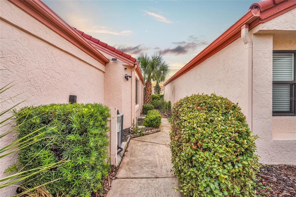 A concrete walkway leads between two stucco houses with red tile roofs and landscaping — 1704 SEA FAIR DRIVE, ST AUGUSTINE, FL