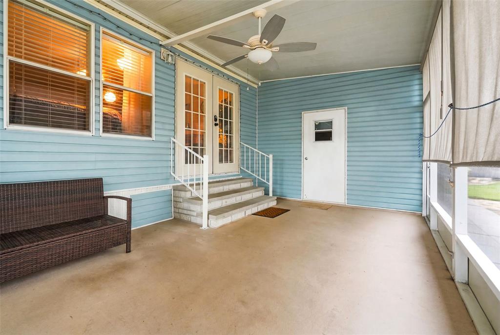 A covered porch with light blue siding, a ceiling fan, steps, and a wicker bench — 6229 KNOTTY PINE DRIVE SE, WINTER HAVEN, FL