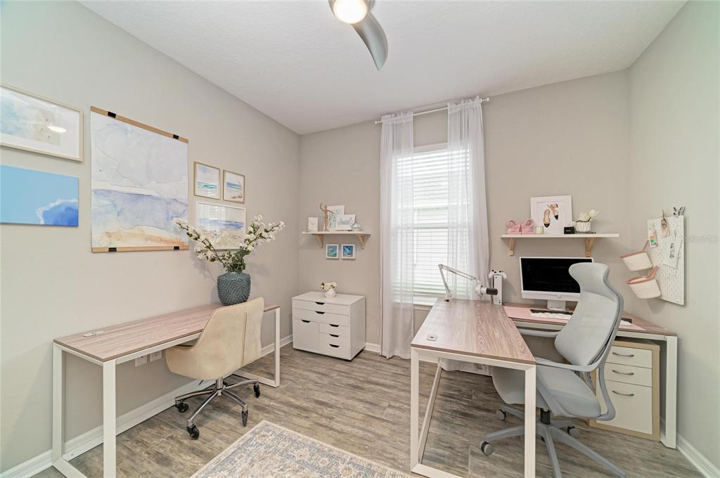 A home office with two desks, light wood flooring, and a window with white curtains — 4714 ROYCROFT TERRACE, PARRISH, FL