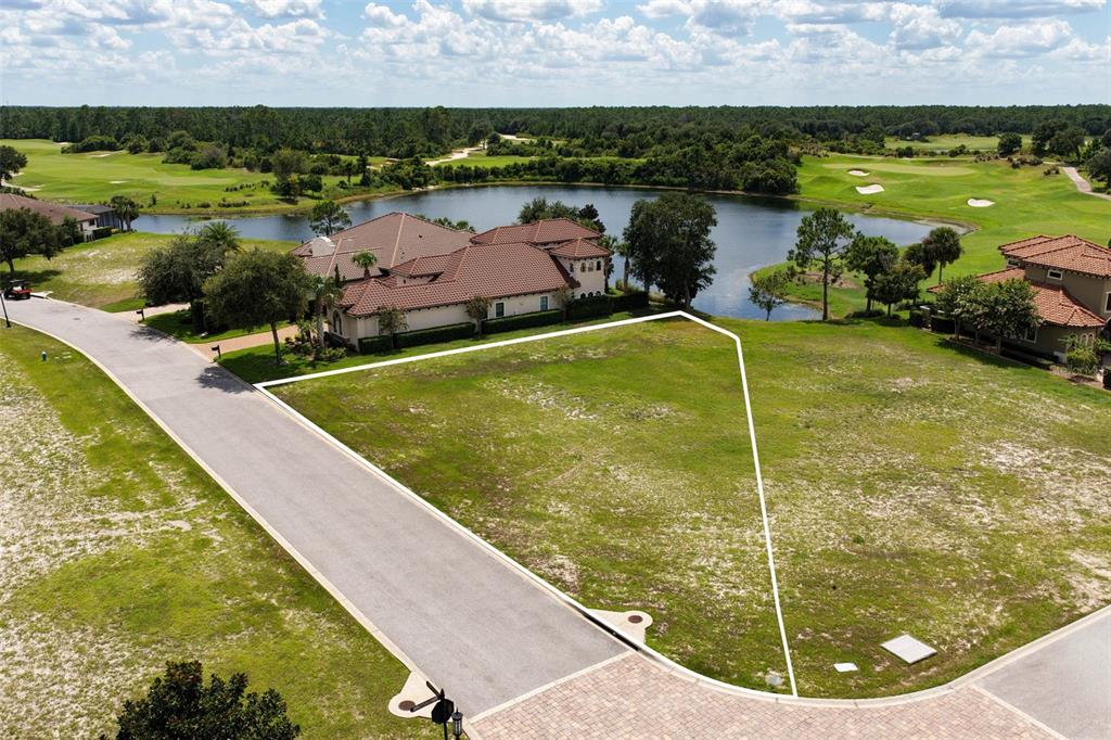 An aerial view shows a vacant residential lot bordered by a road and a lake — 518 SWEETGUM LANE, PALM COAST, FL