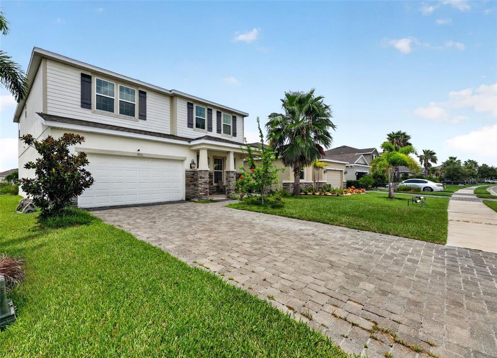 A two-story house with a paved driveway, stone accents, and a white garage door — 6541 DEVESTA LOOP, PALMETTO, FL