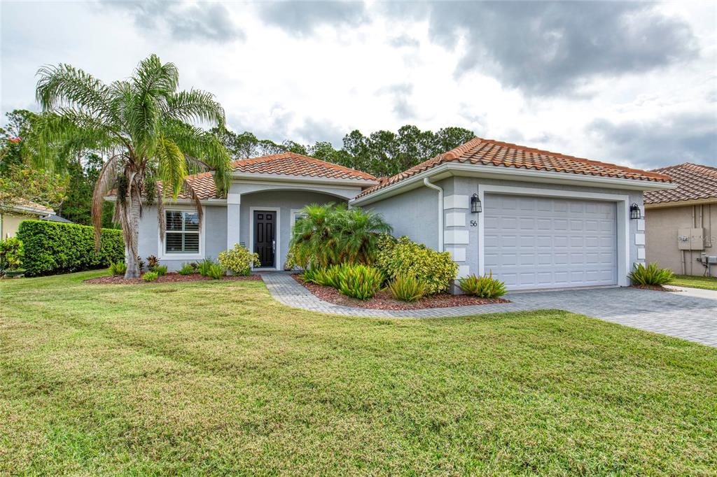 A single-story house with a tiled roof, gray stucco exterior, and a two-car garage — 56 THORNHILL CHASE CIRCLE, ORMOND BEACH, FL