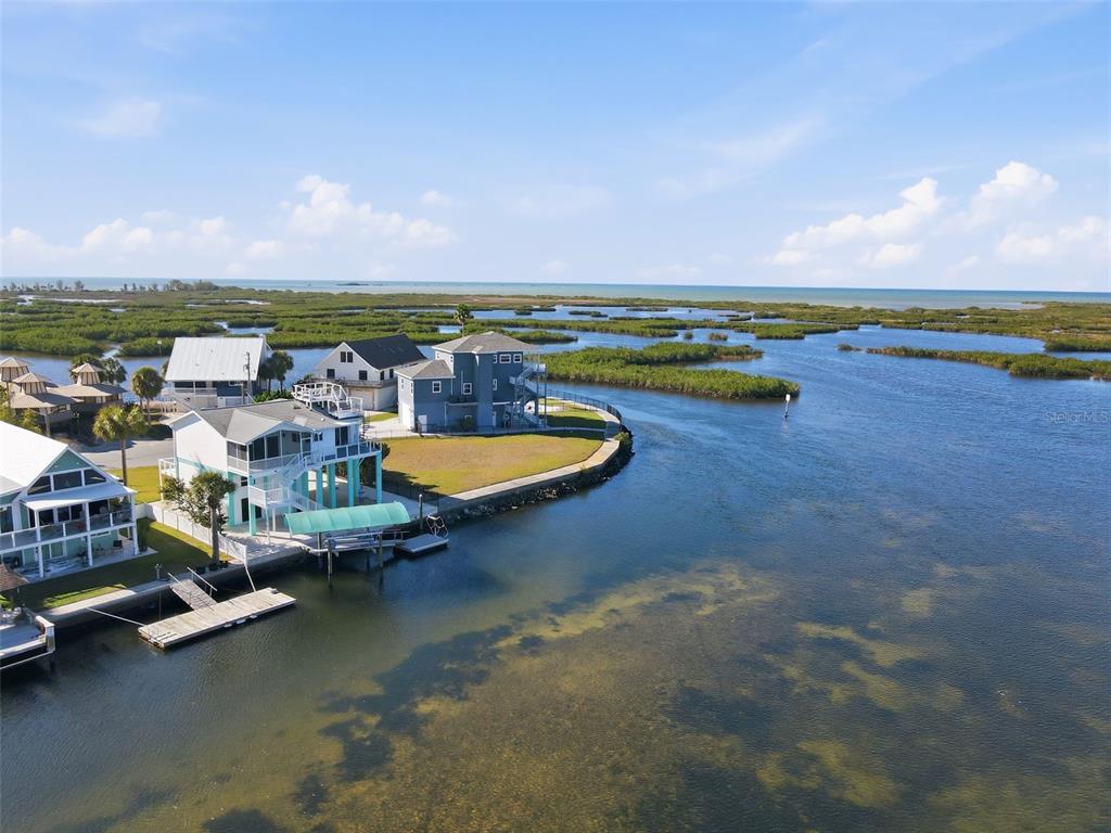 An aerial view shows several waterfront houses situated on a point surrounded by marshland — 3395 EAGLE NEST DRIVE, HERNANDO BEACH, FL