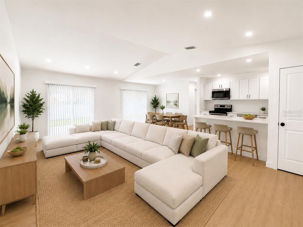 This is a digital rendering of an open-concept living room and kitchen with white cabinetry — 3386 39TH STREET S UNIT B, ST PETERSBURG, FL