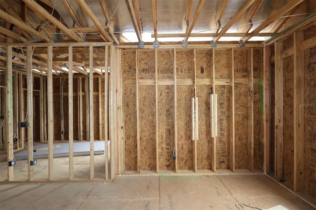 An interior view of a room under construction featuring exposed wooden wall studs and framing — 6759 YELLOW WARBLER BEND, ST CLOUD, FL