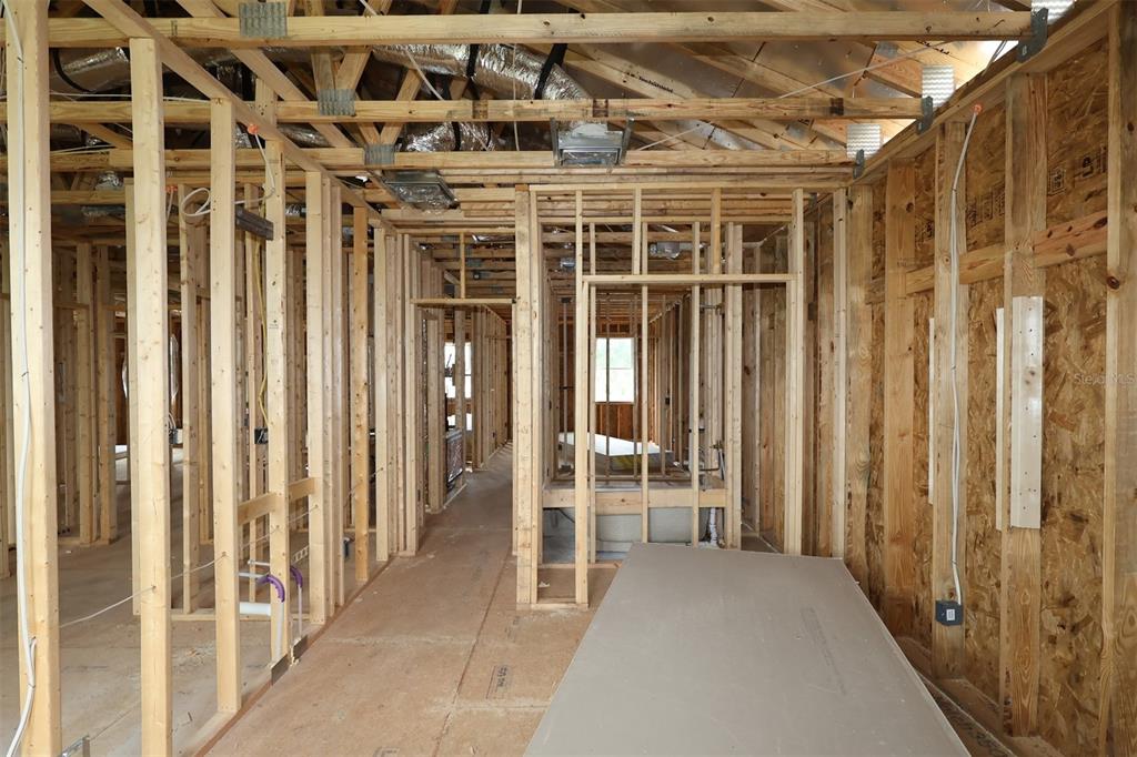 Interior view of a house under construction with exposed wood framing and ceiling ductwork — 6759 YELLOW WARBLER BEND, ST CLOUD, FL