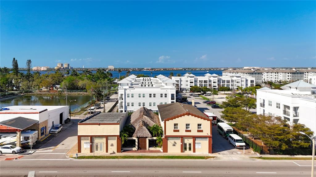 An aerial view shows a street-level commercial building with a thatched roof between two structures — 1001 & 1007 MANATEE AVENUE E, BRADENTON, FL