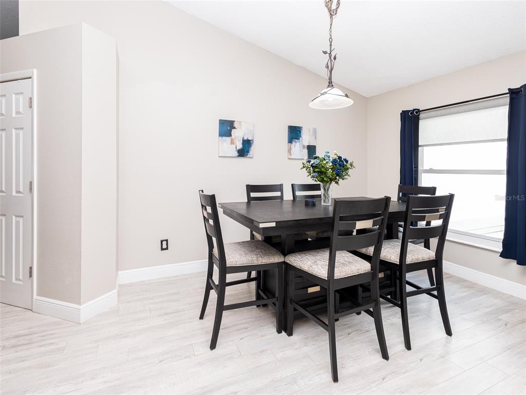 A dining room features a dark wood table with four chairs and light wood flooring — 2540 ROLLING BROAK DRIVE, ORLANDO, FL