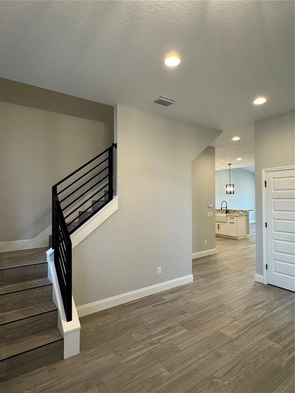 A staircase with black metal railings leads to an upper floor near a kitchen area — 1172 WINDJAMMER DRIVE, LAKELAND, FL