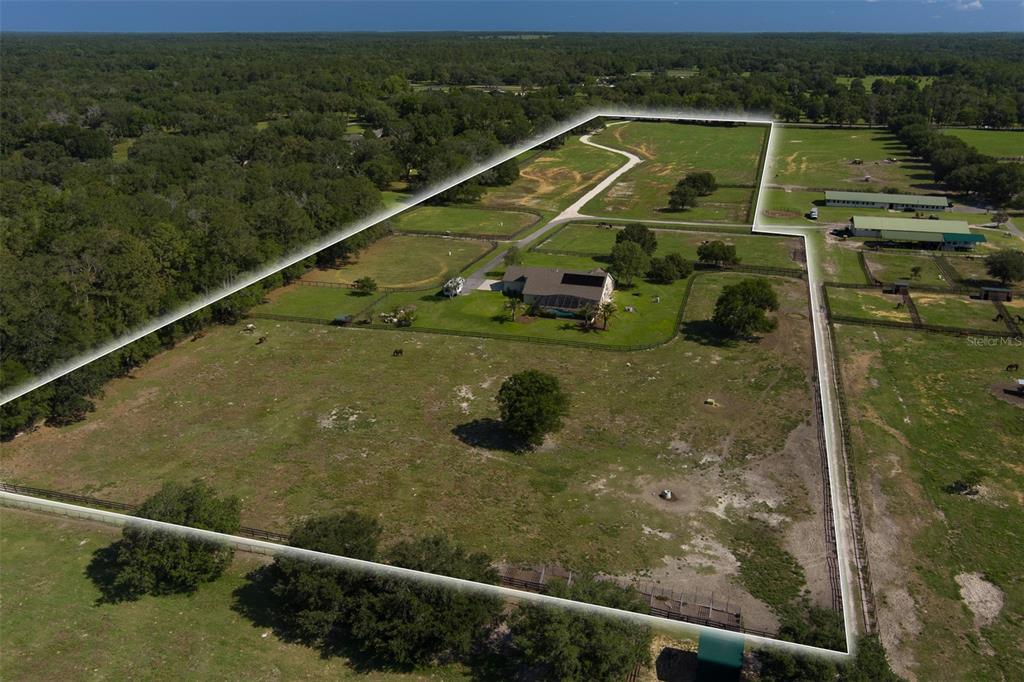 An aerial view shows a house with a pool situated on a large fenced property — 11130 W HIGHWAY 326, OCALA, FL