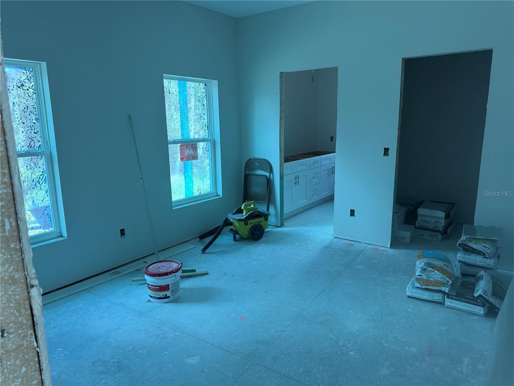 An unfinished room with light blue walls, two windows, and construction materials on the floor — 34281 MANUEL STREET, WEBSTER, FL