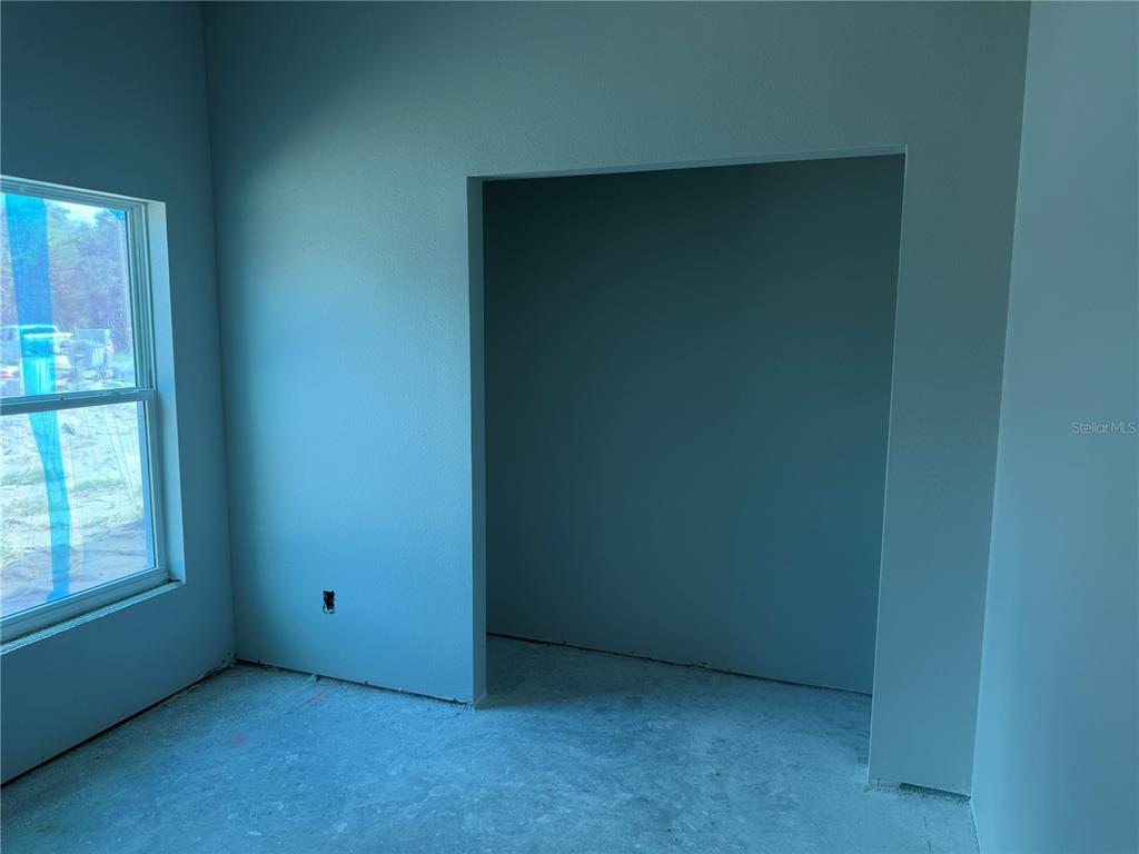 An unfinished room with light blue walls, a window, and a recessed alcove — 34281 MANUEL STREET, WEBSTER, FL
