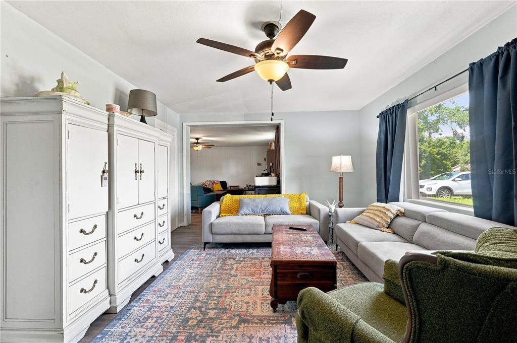 A living room features a ceiling fan, a large white cabinet, and two gray sofas — 603 N CENTRAL AVENUE, OVIEDO, FL