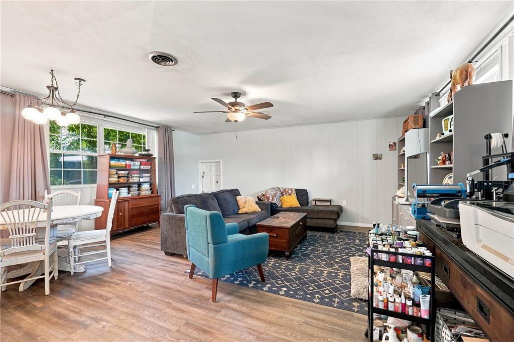 A living room and dining area with wood-look flooring, a ceiling fan, and a rug — 603 N CENTRAL AVENUE, OVIEDO, FL