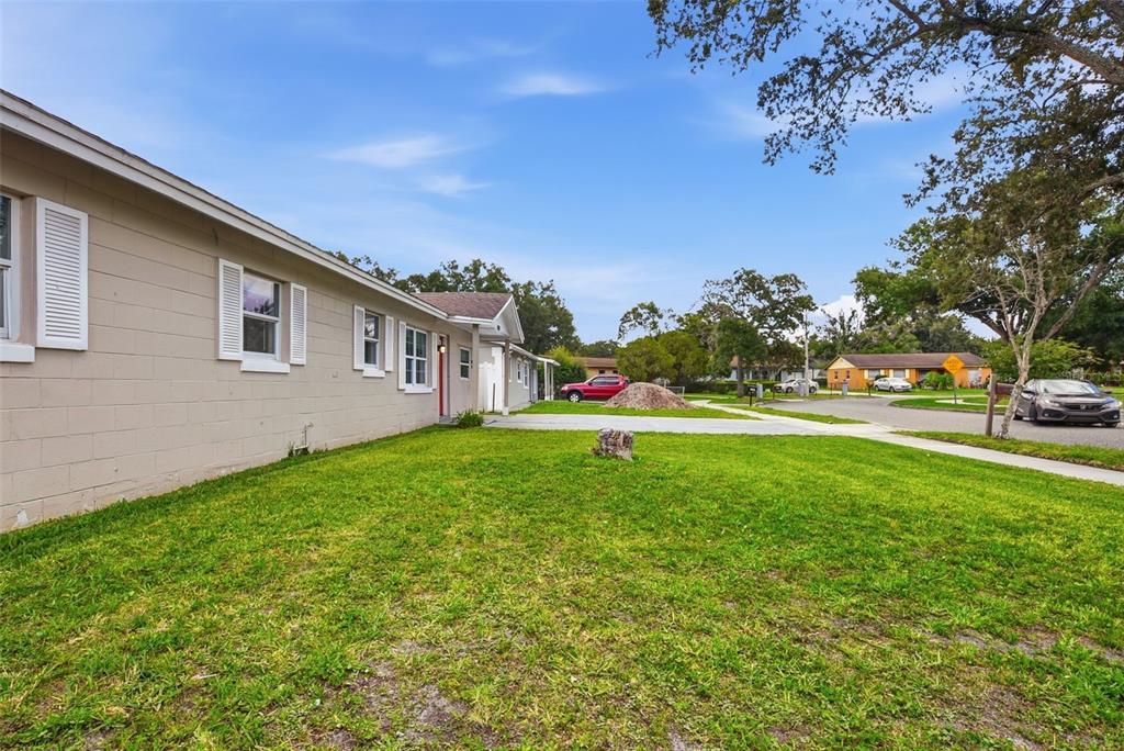 A side view of a beige, single-story house with a lawn and a paved driveway — 4788 PLEASANT VALLEY COURT, ORLANDO, FL