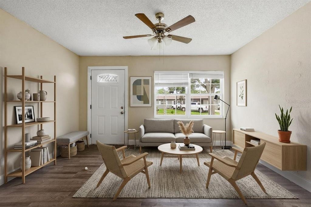A living room with wood-look flooring, a sofa, two chairs, and a ceiling fan — 4788 PLEASANT VALLEY COURT, ORLANDO, FL