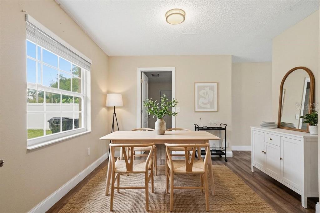 A dining room features a wooden table, four chairs, a sideboard, and a large window — 4788 PLEASANT VALLEY COURT, ORLANDO, FL
