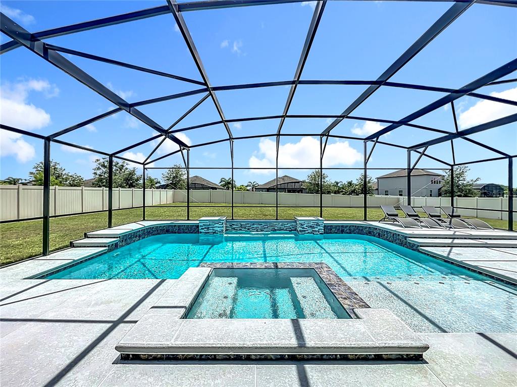 A screened-in swimming pool and spa with light-colored pavers and a vinyl privacy fence — 15084 CUDDY COURT, ORLANDO, FL