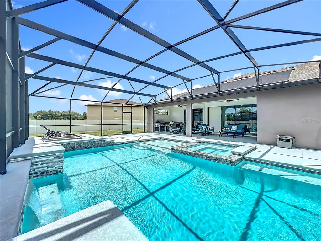 A screened-in swimming pool and spa area features a patio with outdoor furniture — 15084 CUDDY COURT, ORLANDO, FL