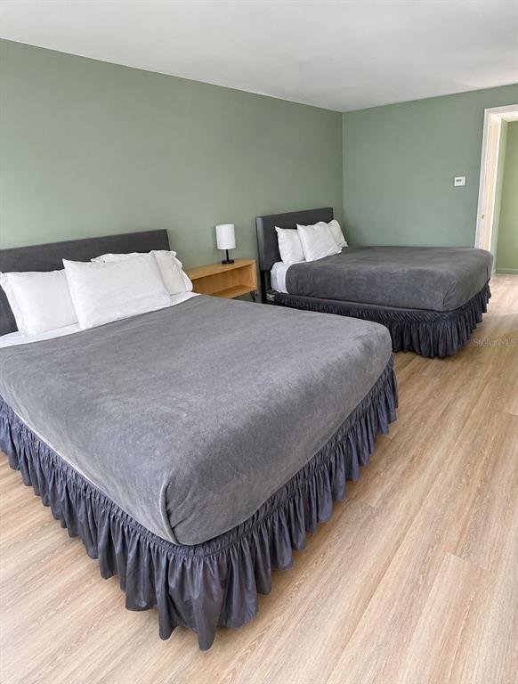 A bedroom features two beds with grey bedding and ruffled skirts against sage green walls — 5245 W IRLO BRONSON MEMORIAL HIGHWAY UNIT 258, KISSIMMEE, FL