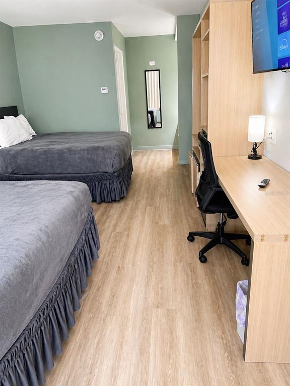 A hotel room features two beds with grey bedding, wood-look flooring, and a built-in desk — 5245 W IRLO BRONSON MEMORIAL HIGHWAY UNIT 258, KISSIMMEE, FL