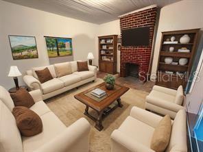 A living room features a brick fireplace, a beige sofa, two armchairs, and wooden bookshelves — 5950 NE HIGHWAY 41, WILLISTON, FL