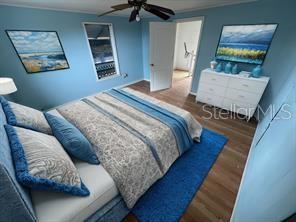 A bedroom with blue walls, a bed with patterned bedding, and a white dresser — 5950 NE HIGHWAY 41, WILLISTON, FL