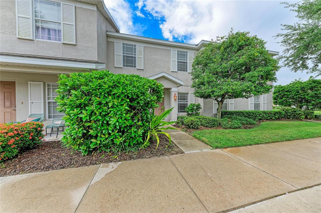 A two-story townhouse exterior features a beige stucco facade, white shutters, and a front walkway — 14745 AMBERJACK TERRACE UNIT 1, BRADENTON, FL
