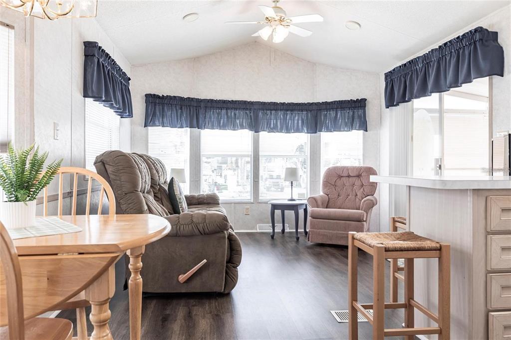 A living room features a brown recliner, a matching armchair, and a wooden dining table — 1604 N MANATEE LOOP, PUNTA GORDA, FL