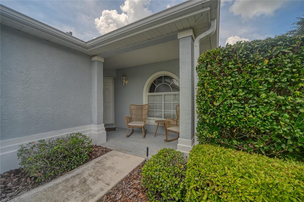 A covered front porch features two wicker rocking chairs and a small table — 1918 NW 50TH AVENUE, OCALA, FL
