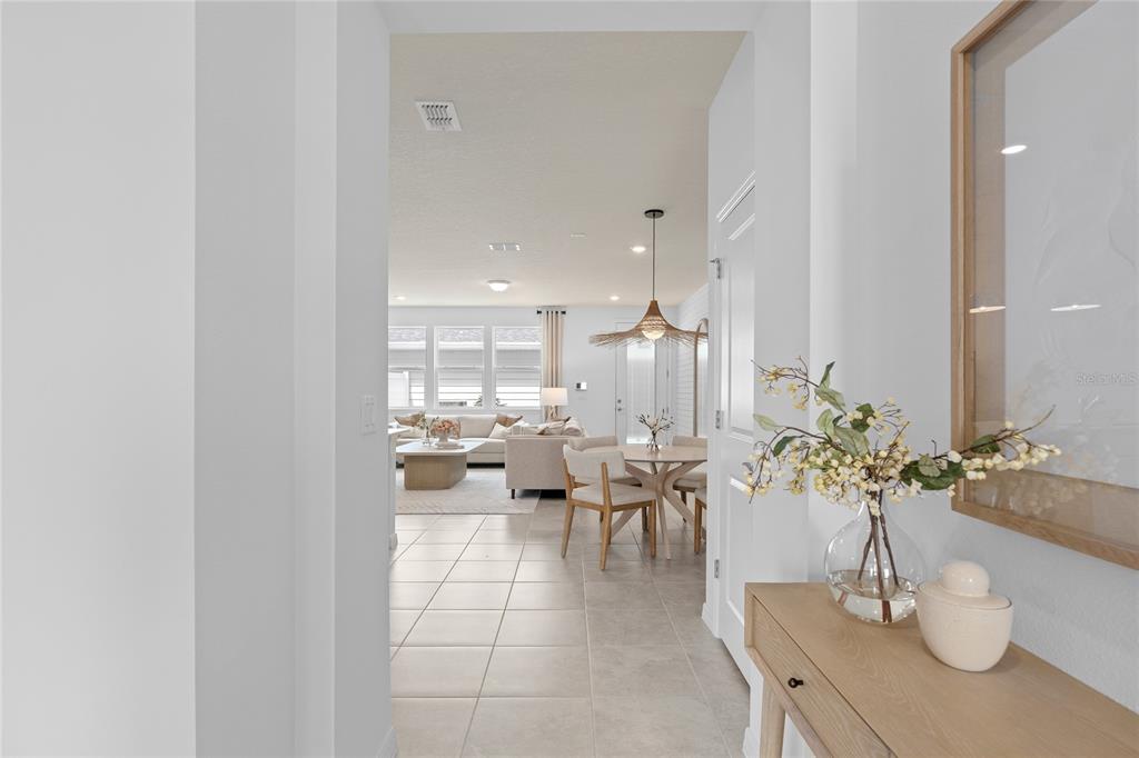 A view from a hallway looks into an open-concept living and dining area with tile — 10502 EVENING STAR STREET STREET, ORLANDO, FL