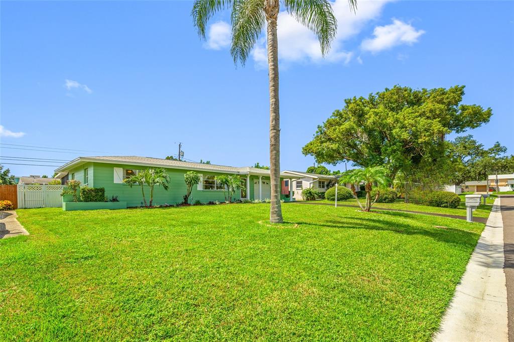 A house exterior features a screened-in patio, a grassy yard, and a white privacy fence — 11450 80TH AVENUE, SEMINOLE, FL