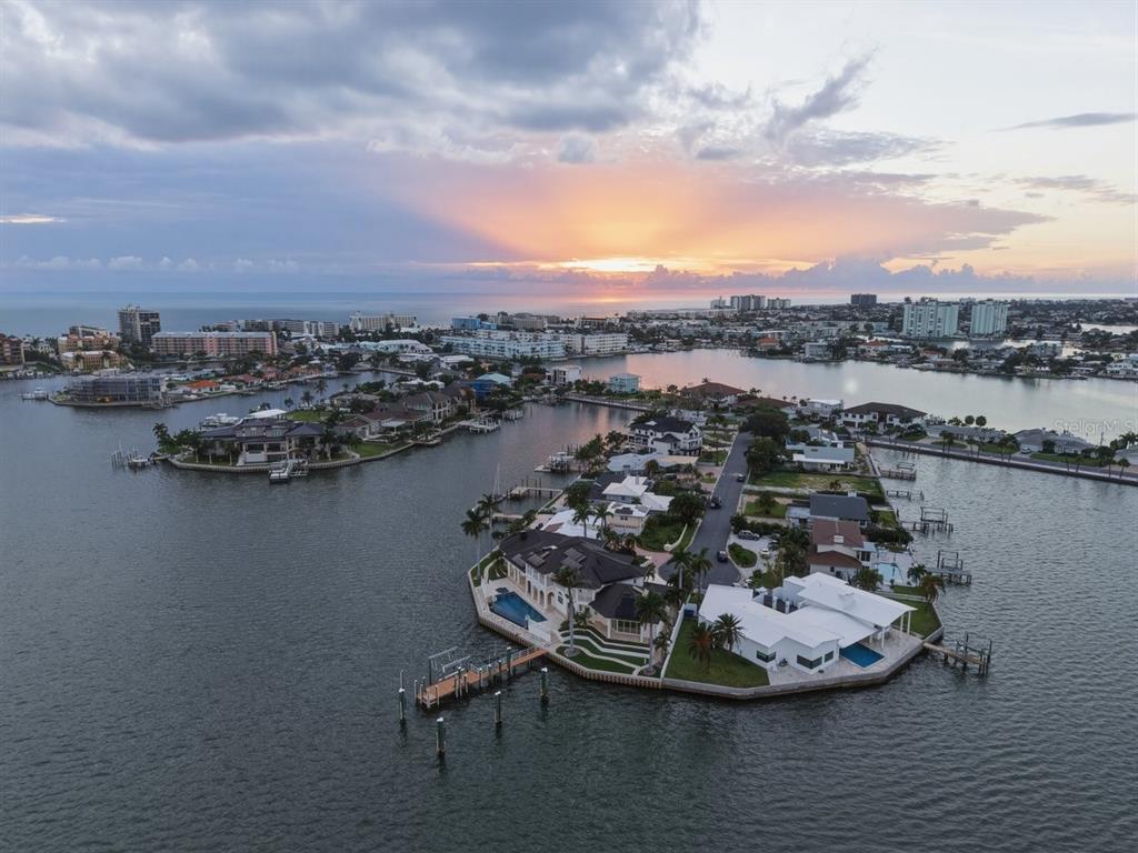An aerial view shows waterfront luxury homes on a peninsula at sunset — 5400 PALI WAY, ST PETE BEACH, FL