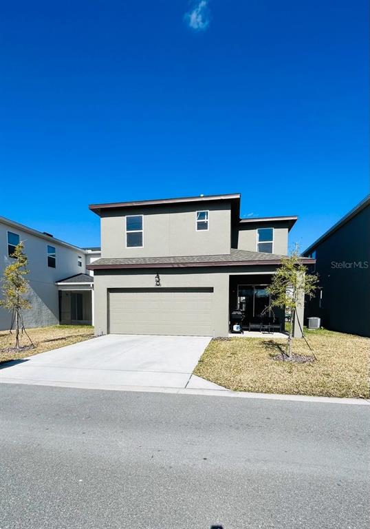 A two-story house with a beige stucco exterior, a two-car garage, and a small front yard — 11926 SUNSAIL AVENUE, ORLANDO, FL