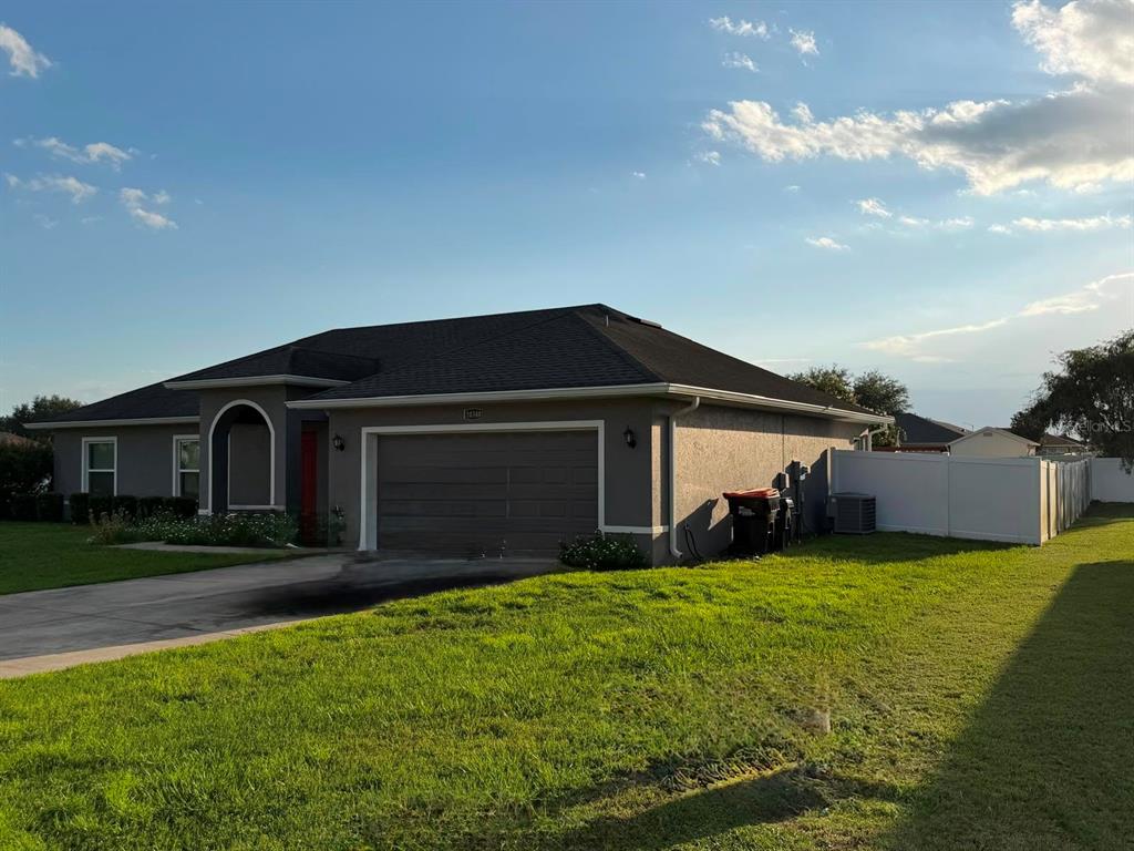 A single-story house with a gray exterior, a two-car garage, and a white vinyl fence — 10340 SE 69TH TERRACE, BELLEVIEW, FL