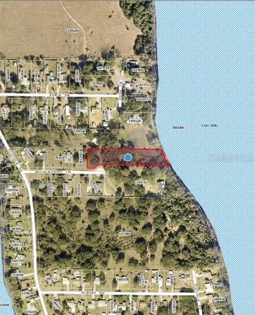 This is an aerial map showing a highlighted rectangular property lot adjacent to a lake — MOCKINGBIRD LANE, FRUITLAND PARK, FL