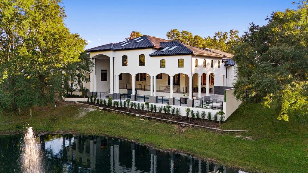 An aerial view of a two-story white stucco house with a tiled roof and pool — 9725 CHESTNUT RIDGE DRIVE, WINDERMERE, FL
