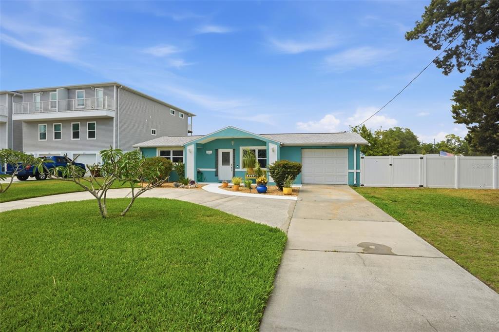 A single-story teal house with a white garage and a concrete driveway — 6907 CLARK STREET, HUDSON, FL